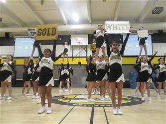 Cheerleaders at rally holding up signs