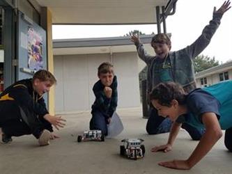 Four boys racing LEGO robots