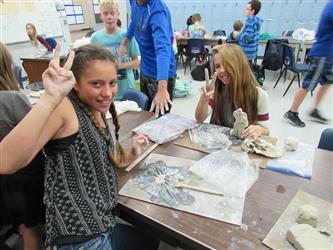 Ceramics student waving to camera