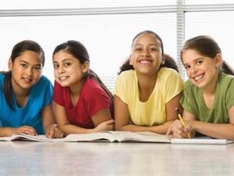 four girls studying and smiling