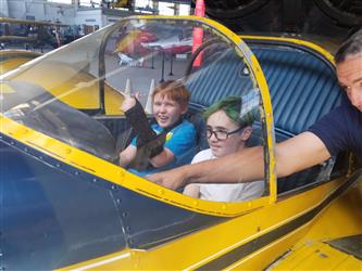 two students in yellow airplane cockpit