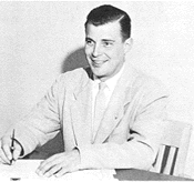 Black and white photo of man signing paperwork