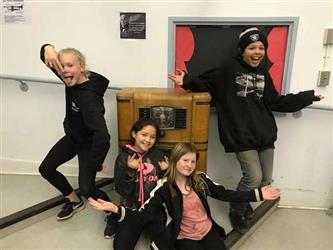 Four drama students doing silly poses around old time radio